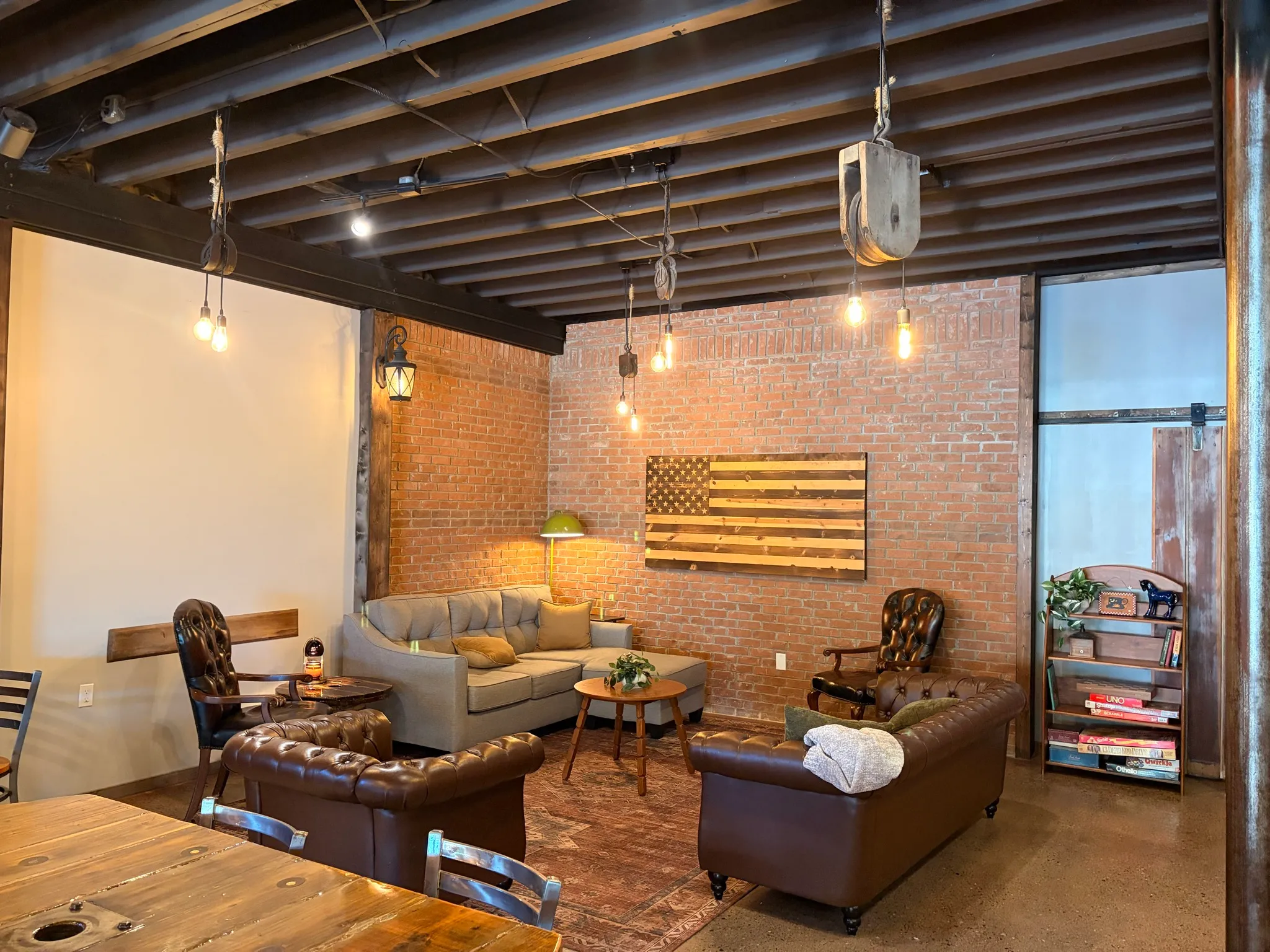The Room seen from the main cafe, with a long wood table in the foreground and a bookshelf of board games